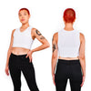 Two images of model showing off the front and the back of the white half binder, hand on hip.
